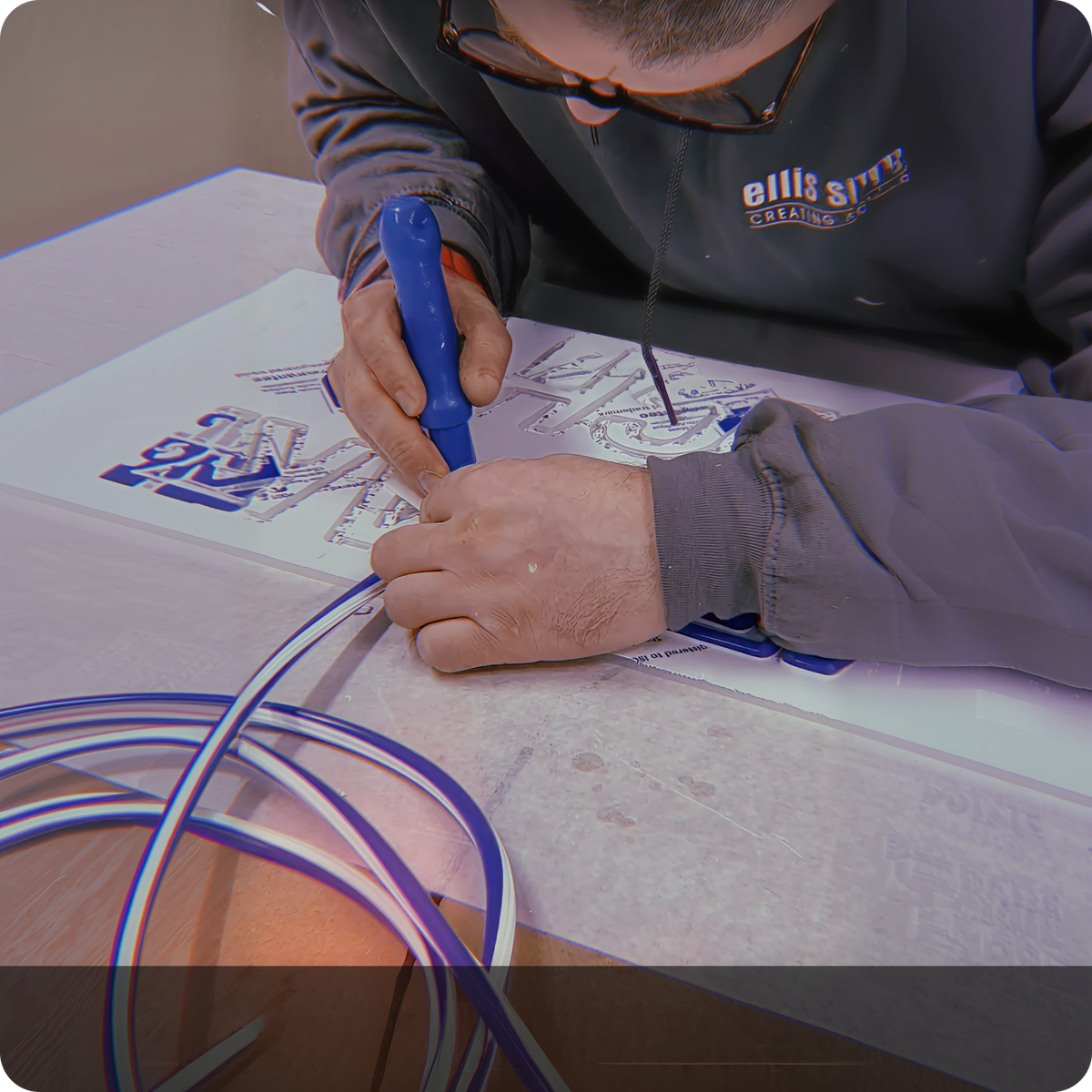 Sign makers assembling a neon sign by hand