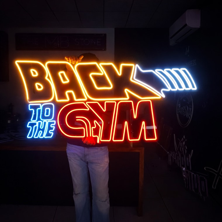 Illuminated studio brand sign above a reception desk