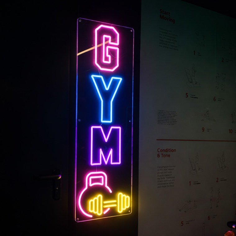 Good Vibes Only neon quote inside a training lounge