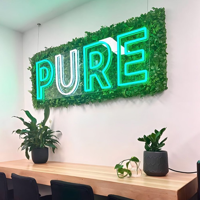 Modern skyline-inspired neon sign above an office lounge