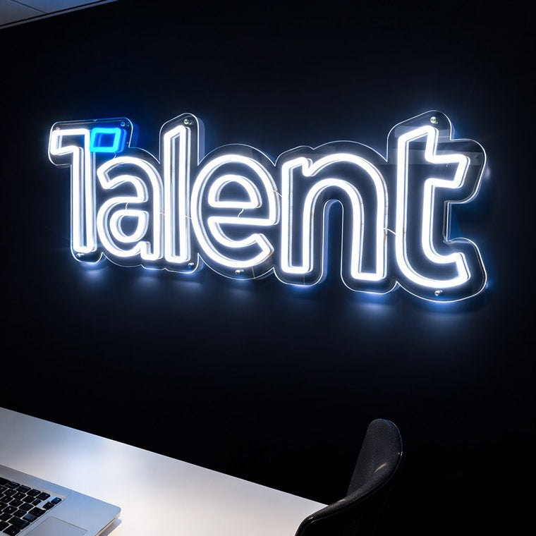 Illuminated Talent logo on a dark reception wall