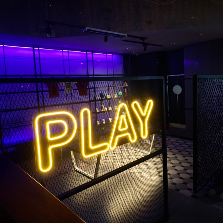 Neon-style retail wall logo in a colorful boutique interior