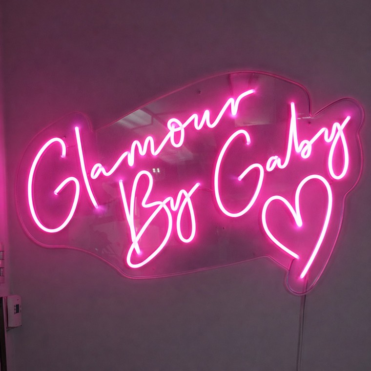 Branded salon wall sign inside a softly lit treatment room